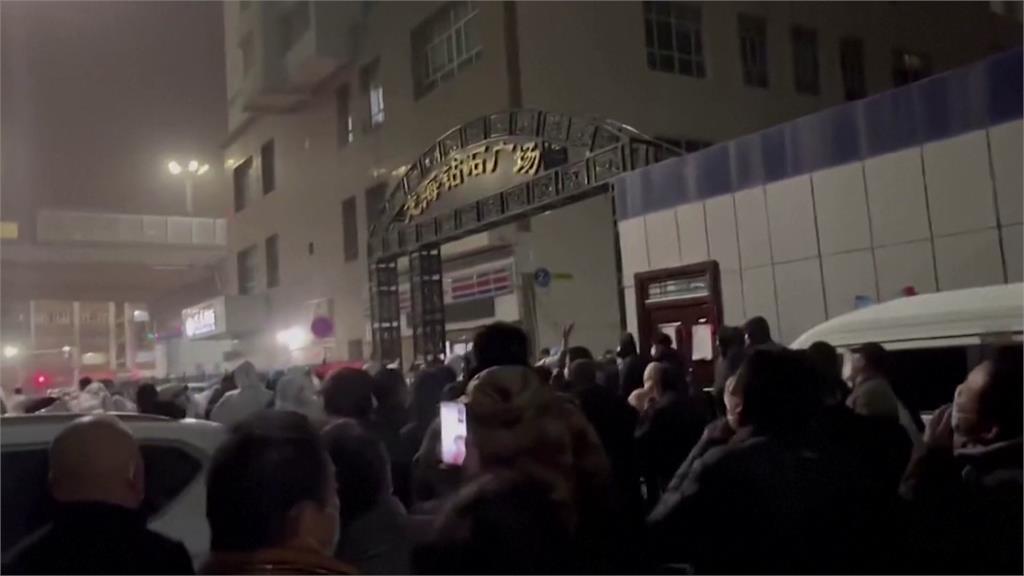 民眾包圍新疆政府大樓，高喊「解封」。圖／路透社