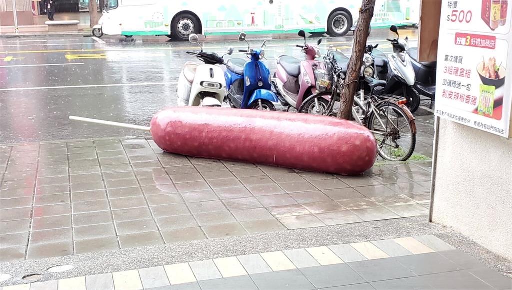 日前高雄苓雅區三多三路上，有一根巨無霸香腸躺在人行道。圖／台視新聞