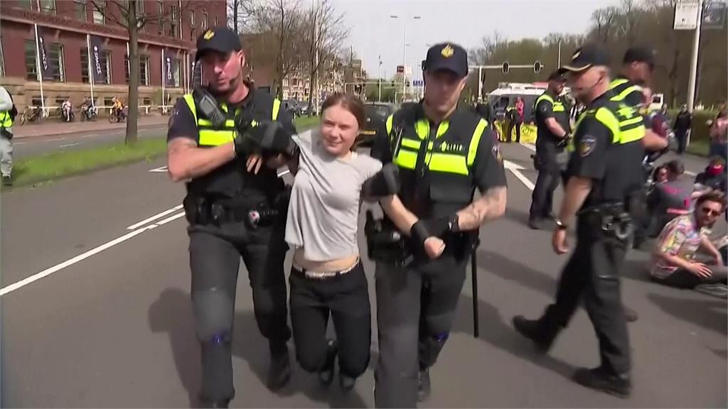 被兩名員警架起，雙腳騰空，瑞典環保運動人士童貝里表情猙獰。圖／美聯社、路透社