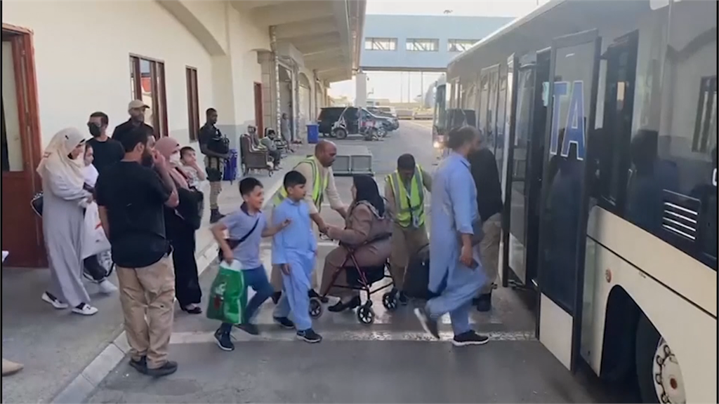 撤離的非阿富汗公民帶著行李，搭上接駁巴士。圖／翻攝自AP Direct