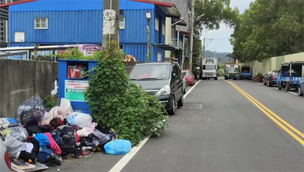 新竹縣南寧路上的舊衣回收箱被塞爆，路邊也堆滿舊衣，影響環境整潔。圖／台視新聞