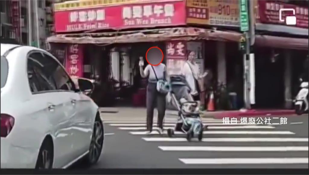 女子推嬰兒車過馬路，走到一半突然拿出手機拍攝，畫面曝光掀起熱議。圖／翻攝自爆廢公社二館