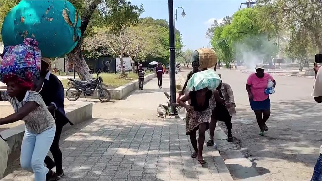 海地首都太子港情勢緊張，當地民眾頂著大包小包逃難。圖／美聯社、CNN