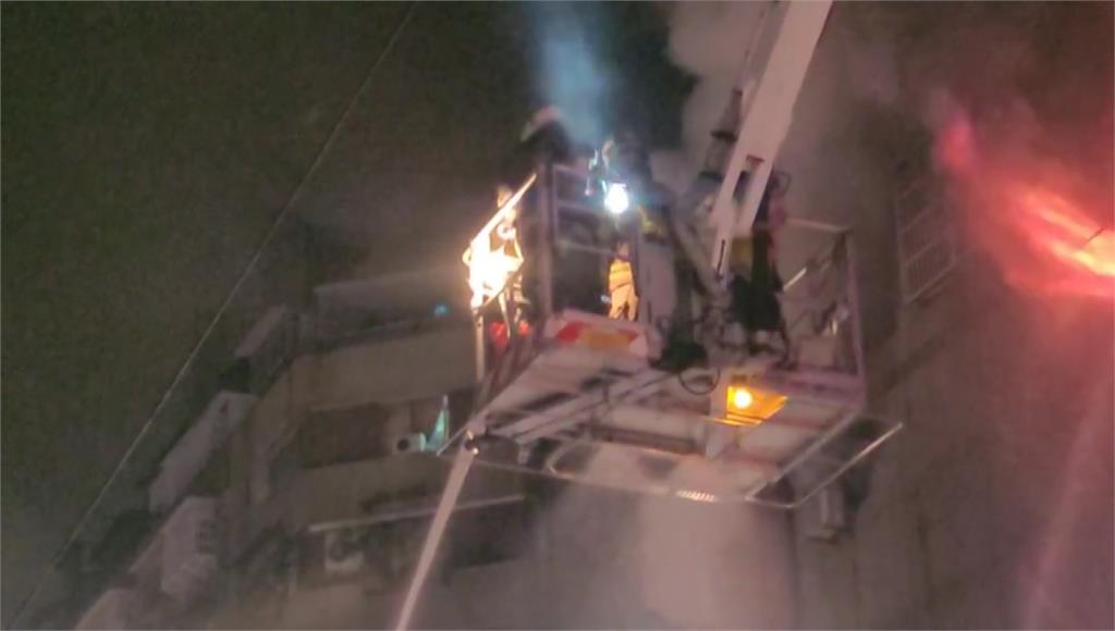 消防人員搭乘雲梯車救出站在窗邊呼救的民眾。圖／台視新聞
