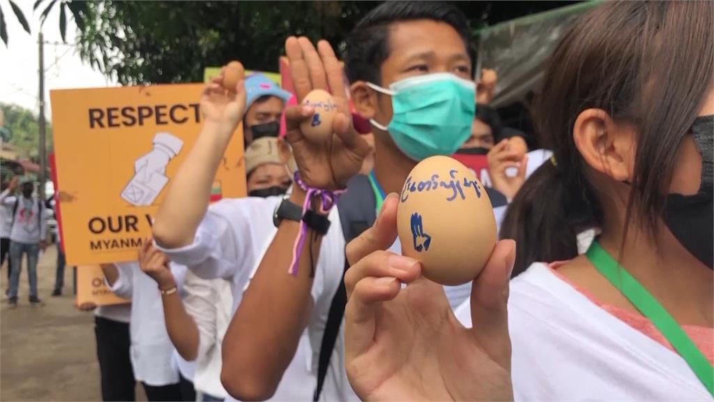 緬甸遊行隊伍舉高舉三指扣住彩蛋。圖／翻攝自AP Direct