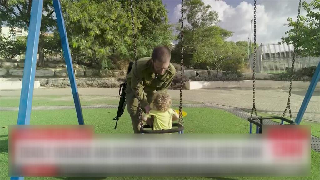 以色列父親帶小孩到公園玩，身上卻背著一把槍。圖／CNN