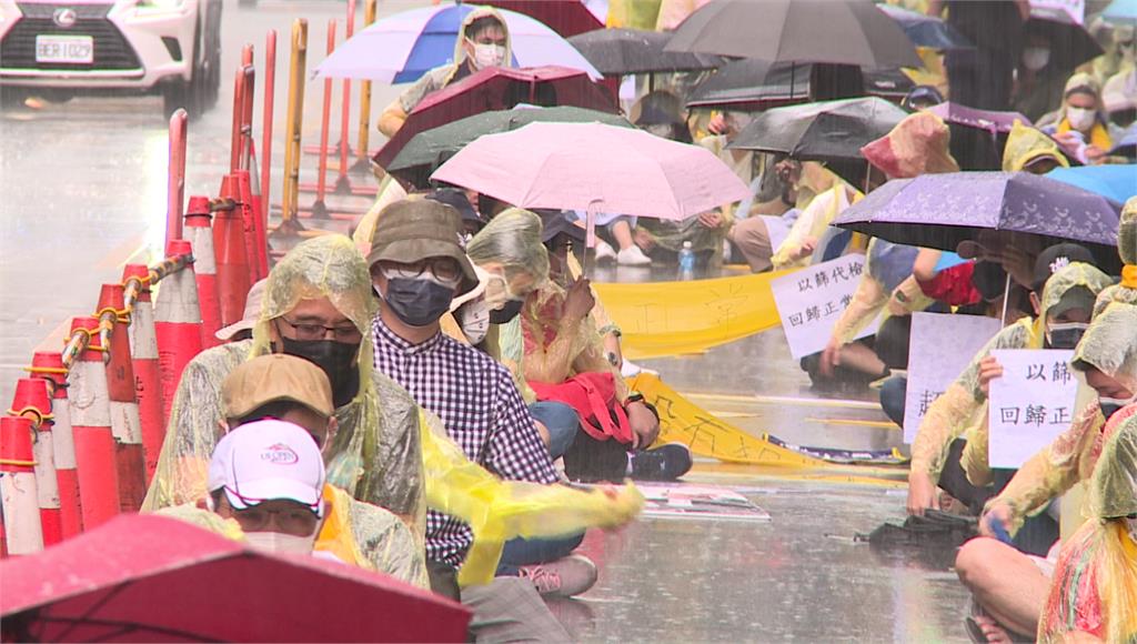 機組員在大雨中抗議。圖／台視新聞