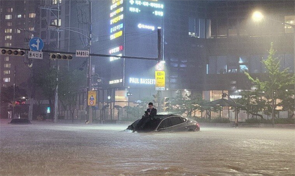 南韓首爾暴雨，汽車慘遭滅頂，人待車頂求援。圖／翻攝自推特 