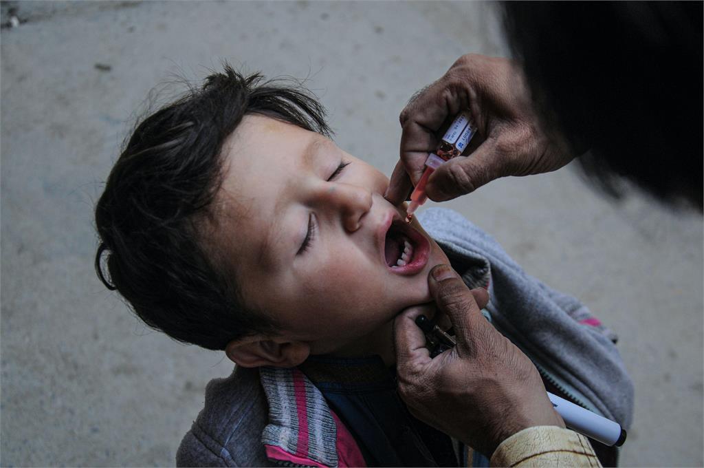 巴基斯坦的衛生人員，為孩童接種口服疫苗。圖／翻攝自Unsplash