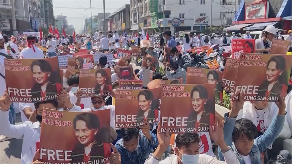 緬甸民眾高舉旗幟標語，要求軍方還政於民，釋放民主女神翁山蘇姬。圖：AP