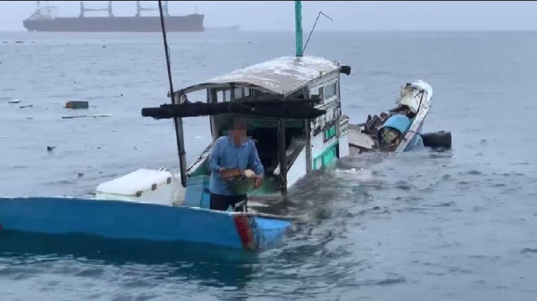 漁民抱著財物，站在船上等待救援。圖／台視新聞