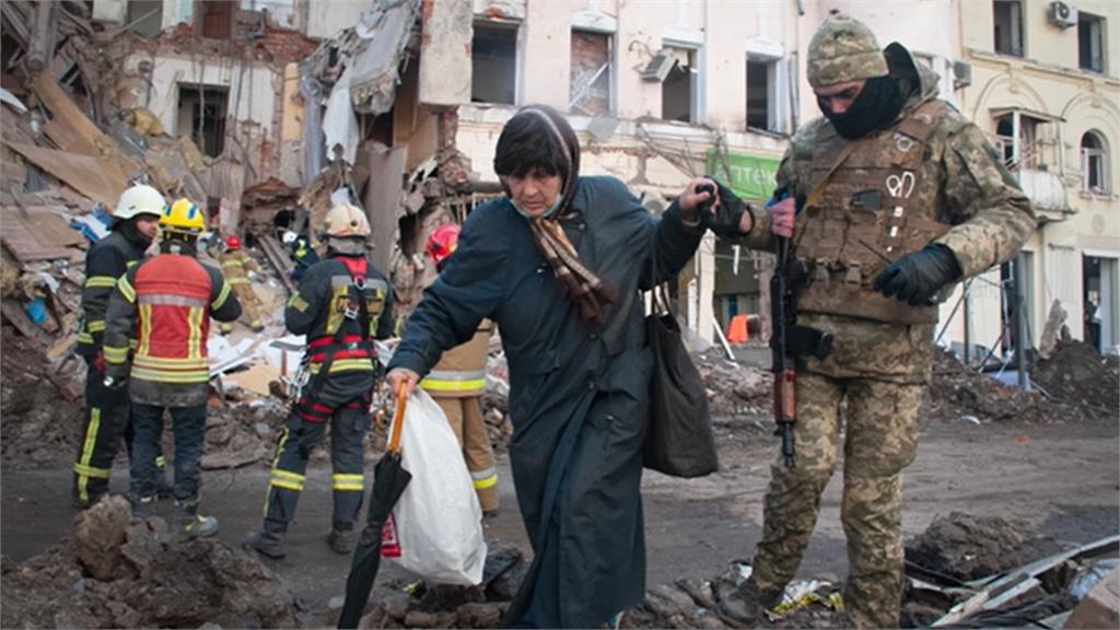 卡爾可夫一名烏克蘭領土防衛部隊志工協助婦女過馬路。圖／翻攝自AP Direct