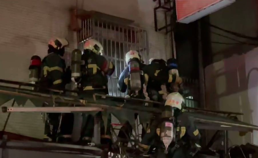 消防人員以破壞工具卸除鐵窗，準備入屋救援。圖：台視新聞