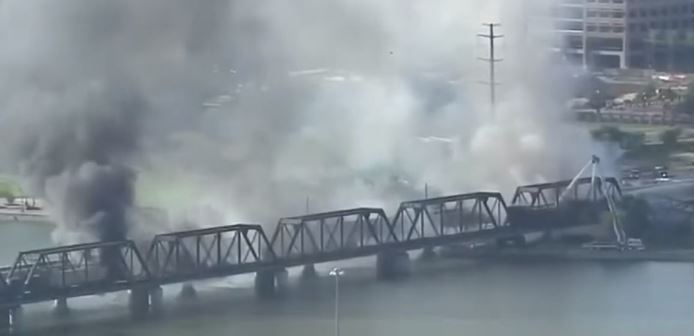 火車意外出軌，使得百年歷史的跨湖大橋起火，冒出濃濃黑煙。圖：翻攝自YouTube
