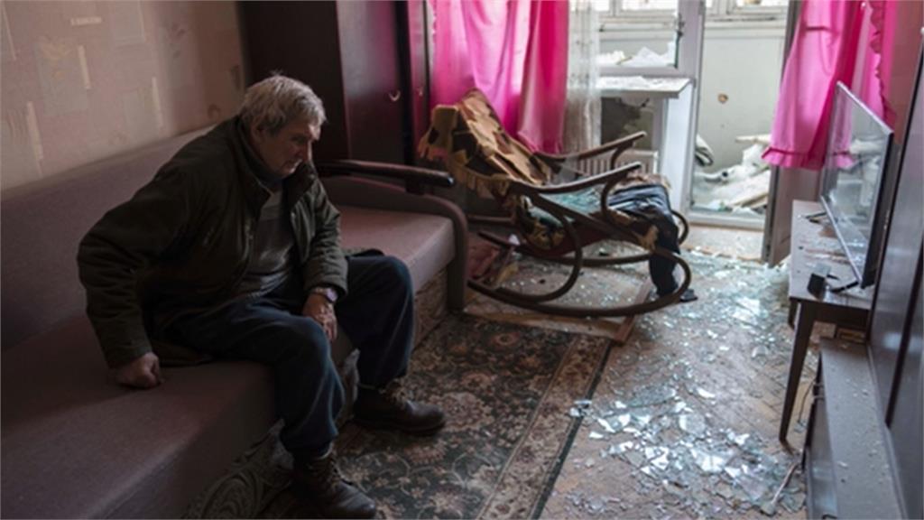 80歲的老翁，在基輔一處被砲擊損毀的公寓內休息，地上滿是碎玻璃。圖／翻攝自AP Direct