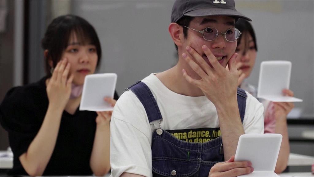 後疫情時代脫口罩，日本「微笑補習班」教你怎麼微笑。圖／路透社